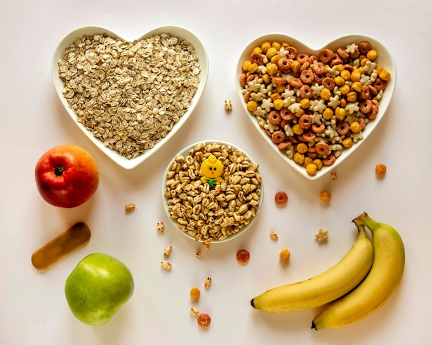 Alimenti per bambini Cereali cereali mela banana kiwi bambino purea di frutta e verdura e biscotti primo piano su sfondo bianco concetto di pubblicità per alimenti per bambini