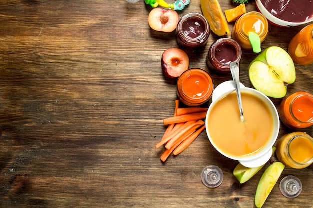 Alimenti per bambini Varie puree di frutta e verdura su uno sfondo di legno