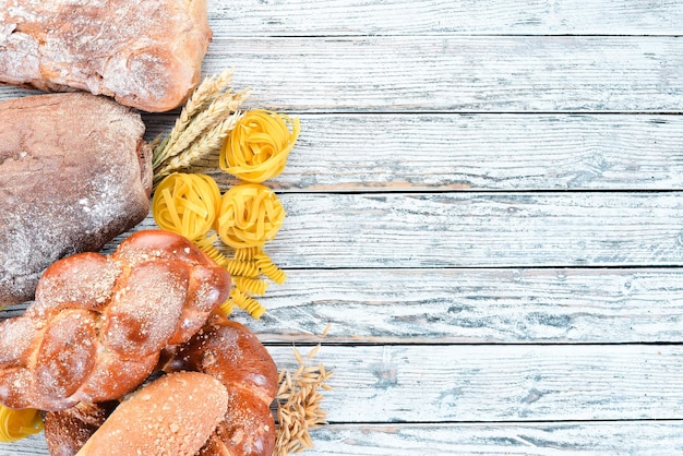 Alimenti senza glutine Vari spuntini e farina di pane su uno sfondo di legno bianco Vista dall'alto Spazio libero per il testo