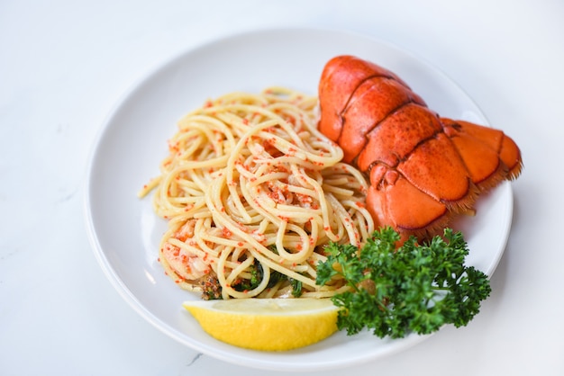 Alimento dell'aragosta dei frutti di mare degli spaghetti su un piatto bianco