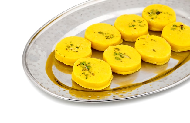 Alimento dolce indiano Kesar Peda su fondo bianco