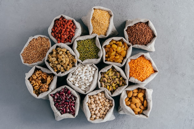 Alimento e legume sani crudi del grano. Sacchi di iuta di cereali e frutta secca.