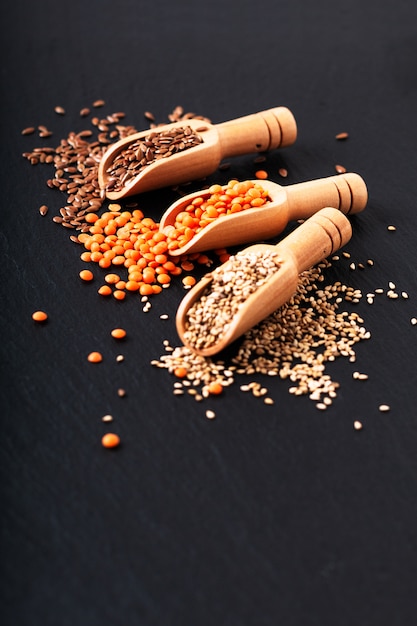 Alimento nutrizionale sano Lino, sesamo e semi di lenticchie arancione in scoop di bambù con lo spazio della copia