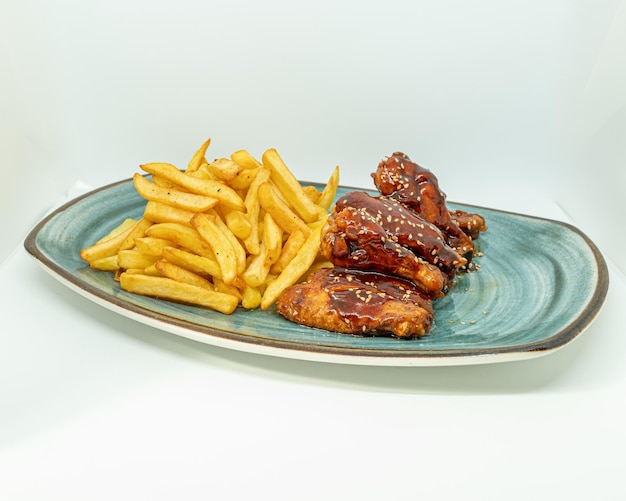 Alitas de barbacoa con patate fritte.