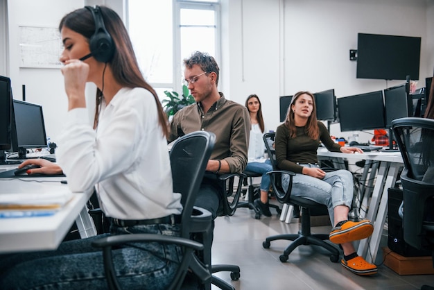 All'interno del call center. Giovani uomini d'affari che lavorano insieme nell'ufficio moderno.