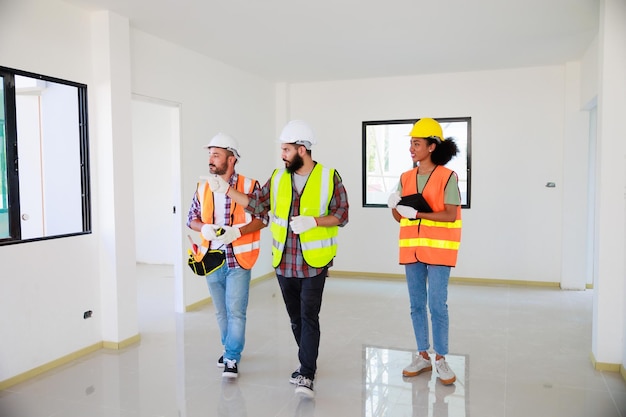 All'interno del team di ingegneri meccanici professionisti che indossano un casco di sicurezza che lavora in una fabbrica di produzione in cantiere