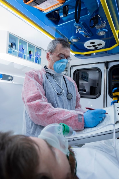 All'interno dell'ambulanza il medico scrive i dati del paziente malato nel notebook Concetto di emergenze