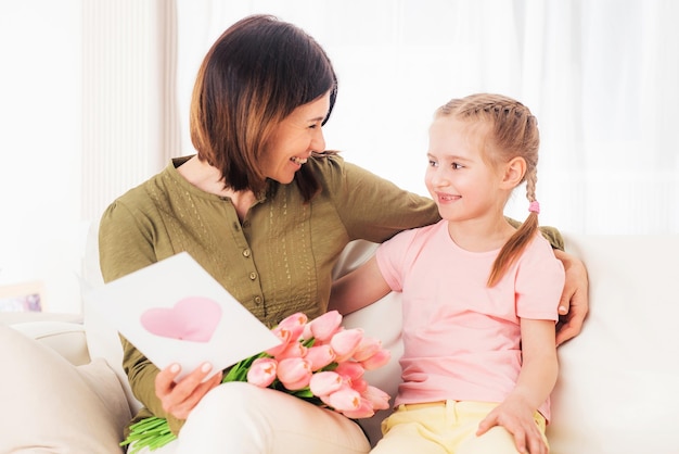 Alla bella mamma piace aprire i regali delle belle figlie per la festa della mamma