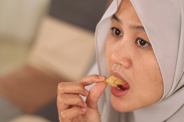 Alla donna musulmana asiatica piace mangiare manioca o patatine fritte