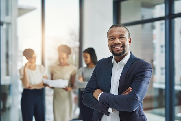 Alla guida di un team di professionisti di livello mondiale. Inquadratura ritagliata di un gruppo di uomini d'affari in piedi in ufficio.