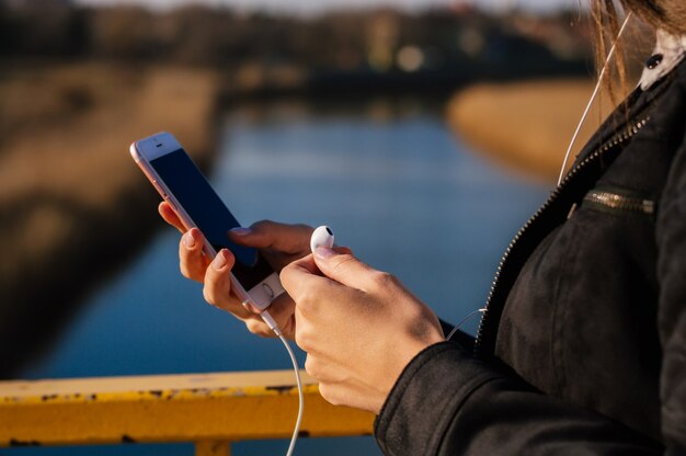 Alla ricerca di un po &#39;di buona musica, primo piano delle mani femminili con lo smartphone