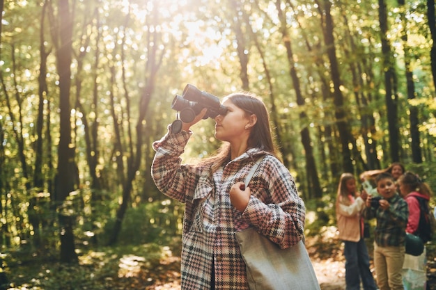 Alla scoperta di nuovi posti Bambini nella foresta verde durante il giorno d'estate insieme