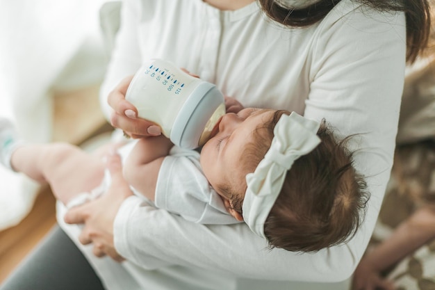 Allattamento al seno Bella giovane madre sta allattando con il biberon il suo bambino di 2 mesi Baby mix Latte materno Maternità