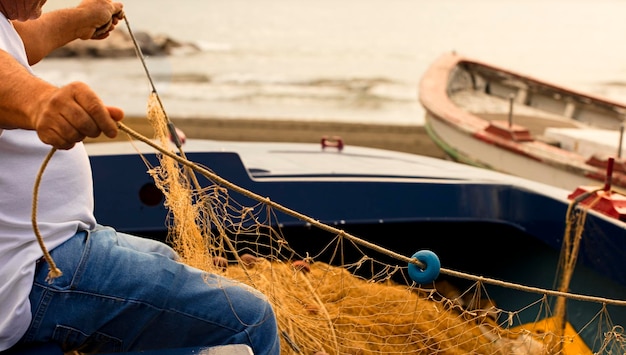 alleate reti con palangari, il pescatore aggiusta e prepara il materiale per lavorare in mare