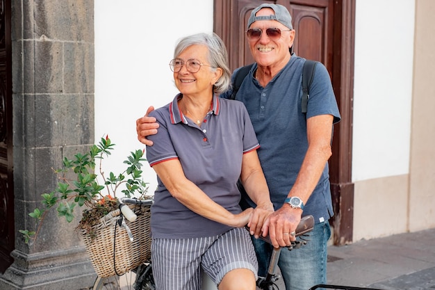 Allegra coppia senior seduti all'aperto sulla bicicletta godendo di una giornata di sole durante un viaggio di piacere