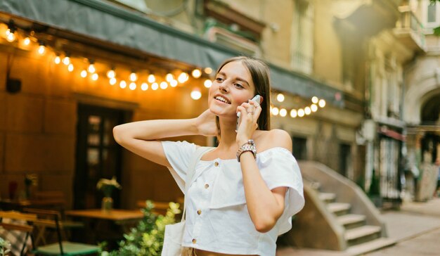 Allegra donna carismatica parla al telefono mentre si cammina la sera