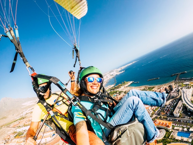 Allegra donna felice per l'esperienza con il paraglide con il pilota