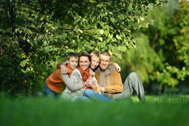 Allegra famiglia di quattro persone che si rilassano nel parco in autunno