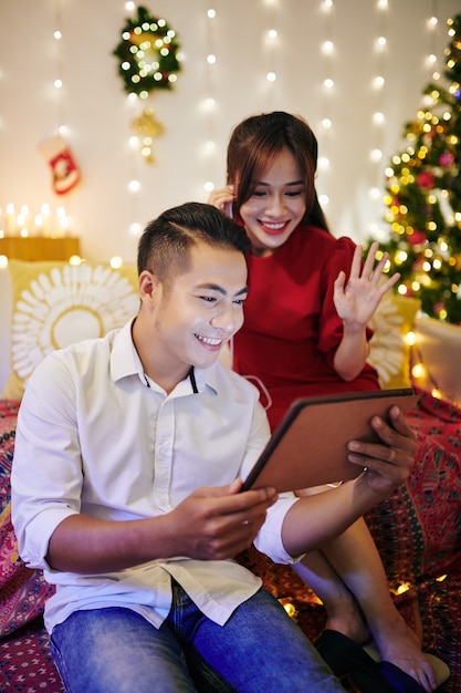Allegra giovane coppia asiatica video che chiama i loro parenti e amici alla vigilia di Natale