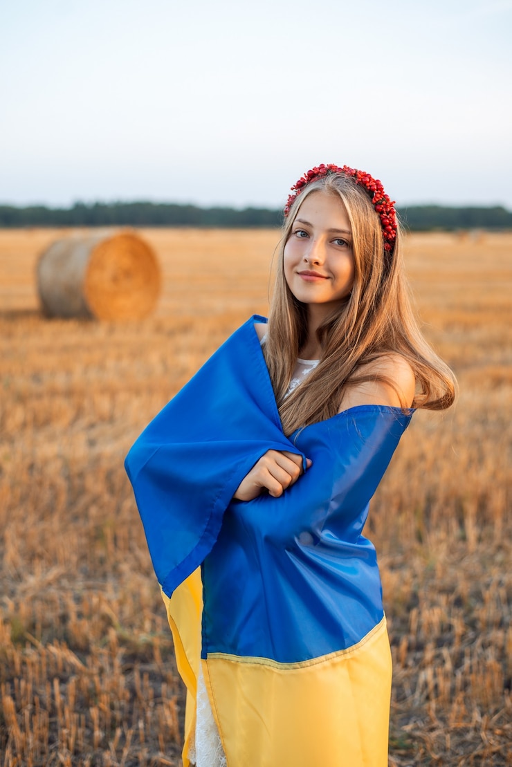 Foto allegra ragazza ucraina avvolta nella bandiera nazionale dell'ucraina in campo agricolo