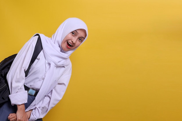 Allegra studentessa indonesiana in uniforme che indossa uno zaino sorridente