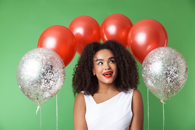 Allegro abito da portare donna africana che celebra con palloncini isolati