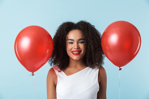 Allegro abito da portare donna africana che celebra con palloncini isolati