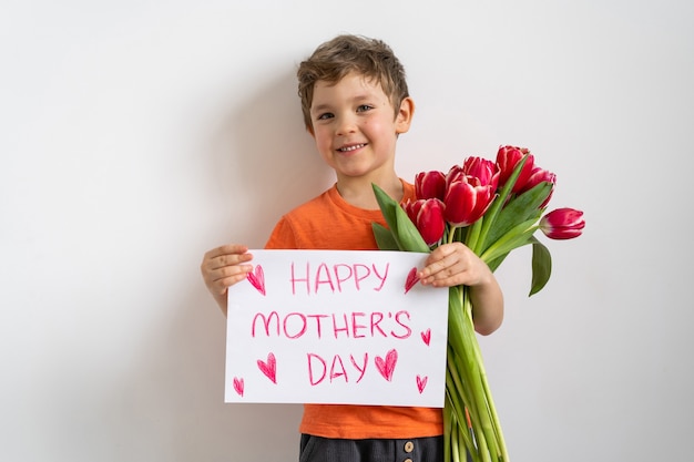 Allegro bambino felice con bouquet di fiori di tulipani.