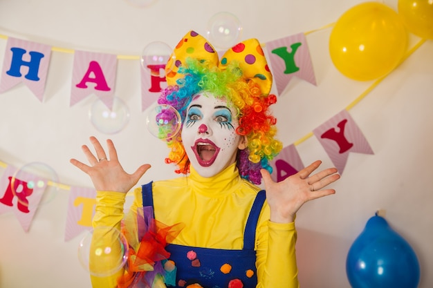 Allegro clown ragazza in vacanza tra bolle di sapone