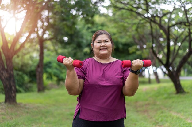 Allenamento asiatico della donna grassa all'aperto che si esercita nel parco, sport e ricreazione per il concetto di idea di perdita di peso.