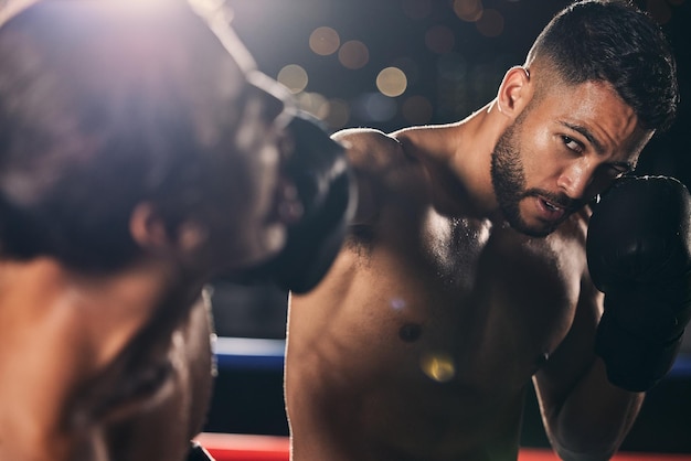 Allenamento benessere e fitness pugilato uomo pugno con esercizio allenamento e combattimento in studio o palestra nell'arena buia Pugile sportivo e allenatore che combattono per la salute in competizione torneo o evento estremo