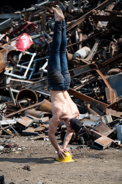 Allenamento dell'uomo delle flessioni in verticale alla discarica industriale