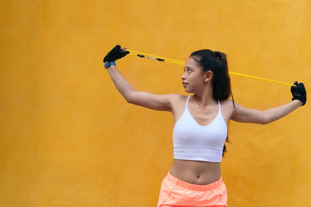 Allenamento della donna latina con elastici di resistenza