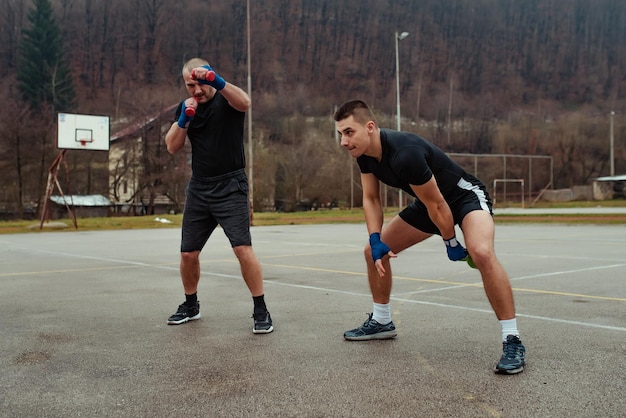 Allenamento di lavoro di due atleti con kettlebell e manubri