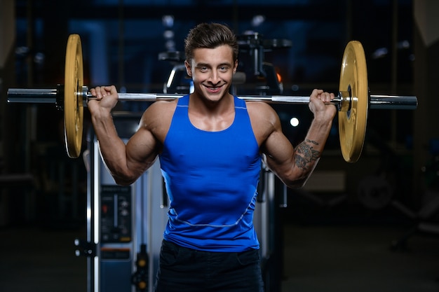 Allenamento di modello bello del giovane in palestra