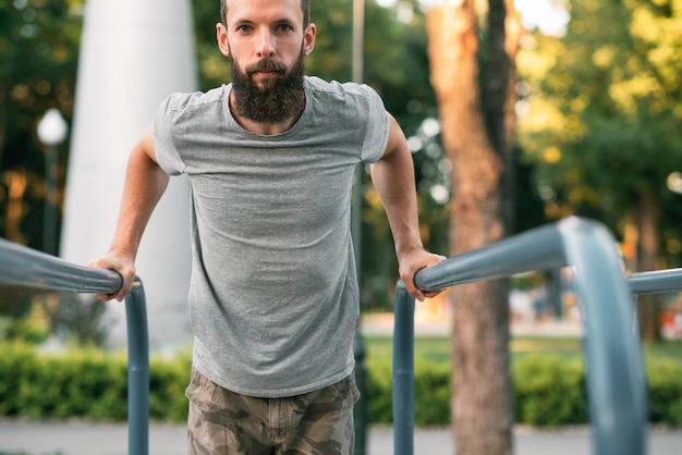 Allenamento di strada e stile di vita atletico uomo che fa sport e allenamento con la barra parallela