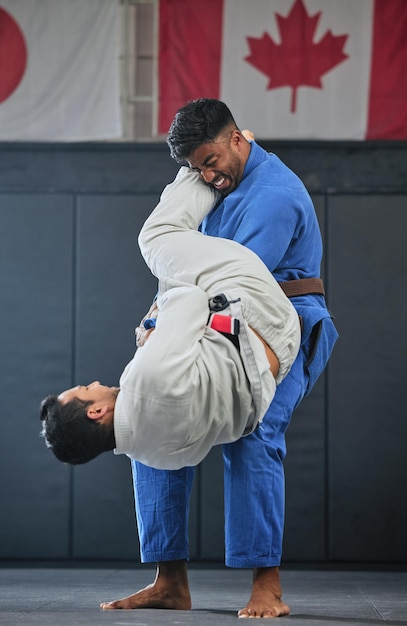 Allenamento e combattimento di MMA con uno studente e un insegnante che si esercitano durante un allenamento di autodifesa in una palestra o in uno studio di combattimento Sport da combattimento con un combattente e il suo avversario in gi o uniforme in una partita