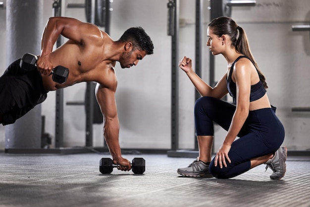 Allenamento e motivazione con un fitness coach o un personal trainer e il suo studente bodybuilder durante un allenamento in palestra Sport e benessere con un'atleta sana che fa esercizio