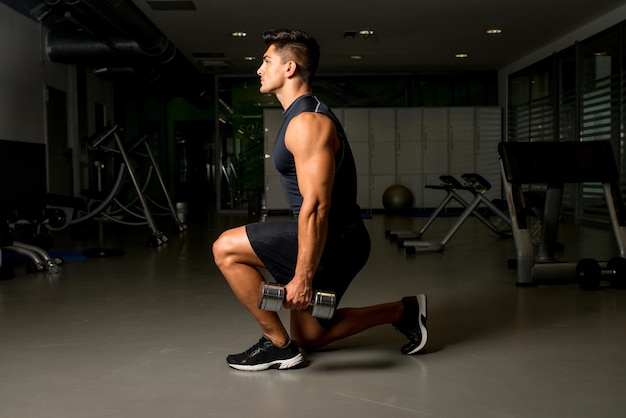 Allenamento in palestra con affondo con manubri