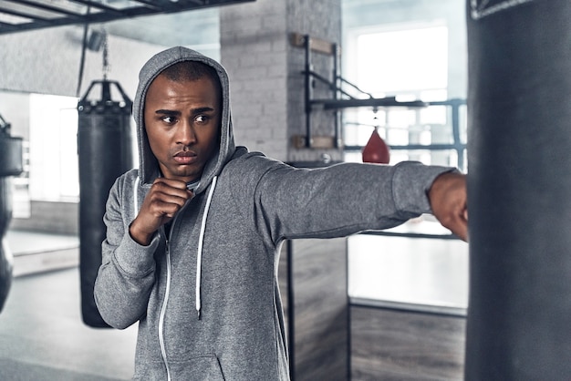 Allenamento per il grande giorno. Bel giovane africano in abbigliamento sportivo boxe