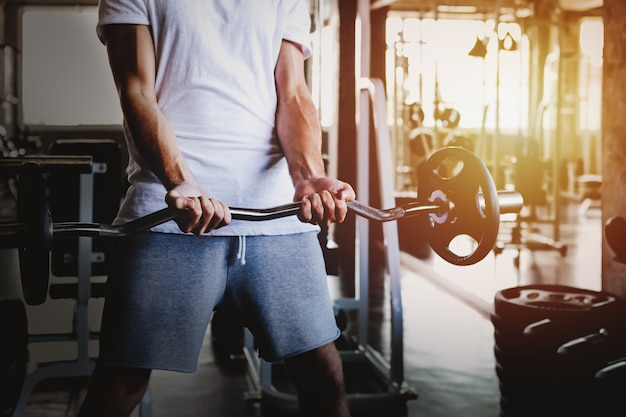 Allenamento sano della testa di legno della tenuta degli uomini del primo piano e corpo della costruzione a forma fisica della palestra