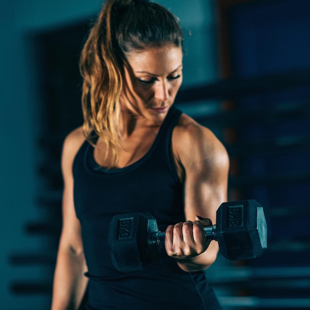 Allenamento trasversale Giovane donna che si esercita con i dumbbells