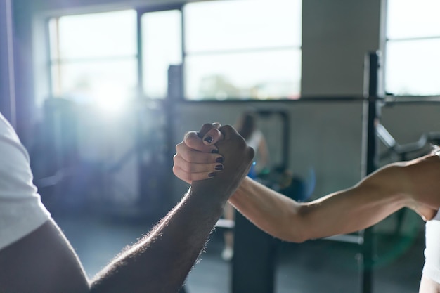 Allenatore e donna fitness si stringono la mano l'un l'altro