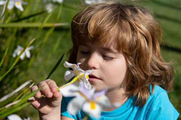 Allergia ai fiori nei bambini Parco primaverile con fiori Ragazzino che annusa il narciso all'aperto