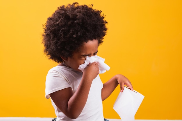 Allergie o concetto di freddo. piccola ragazza afro che si asciuga il naso freddo