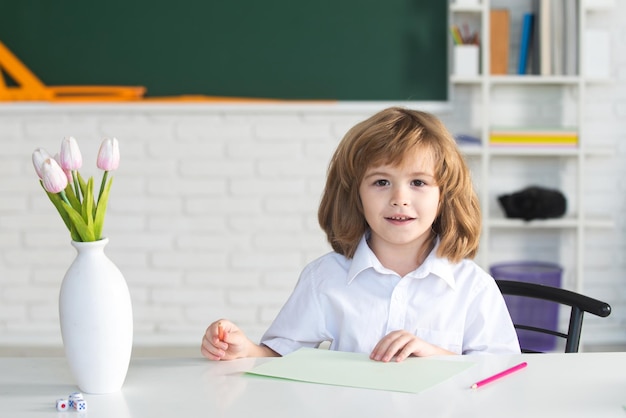 Allievo della scuola primaria i bambini della scuola contro la lavagna verde il bambino si prepara per la scuola