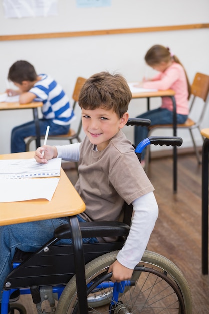 Allievo disabile che scrive allo scrittorio in aula