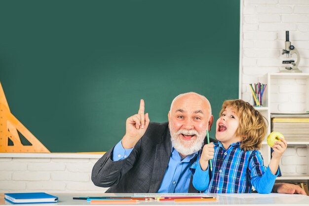 Allievo e insegnante in classe Nonno e figlio che si divertono insieme Insegnante e allievo uomo maturo su sfondo balckboard