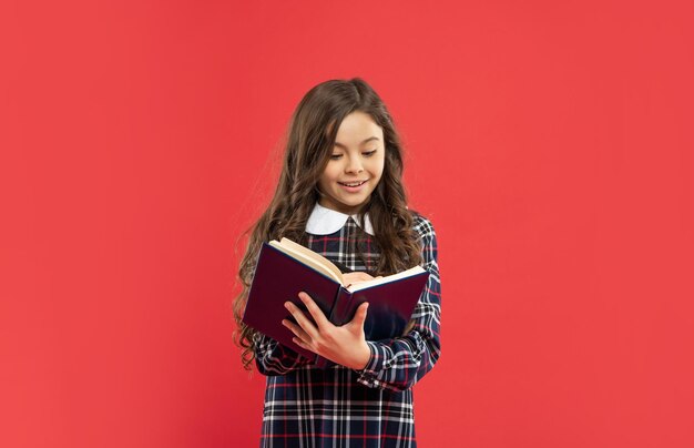 Allievo o studente positivo che prende appunti nello studio della ragazza teenager del taccuino con il libro