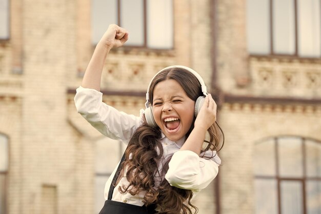 Allievo sorridente Vero successo Canzone felice Tempo libero e riposo Acconciatura splendida Bambino felice all'aperto Studentessa allegra Studentessa rilassante Concetto di infanzia felice Giornata internazionale dei bambini